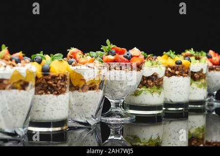 Selektiver Fokus von frischem Müsli mit frischen Früchten und Beeren isoliert auf Schwarz Stockfoto