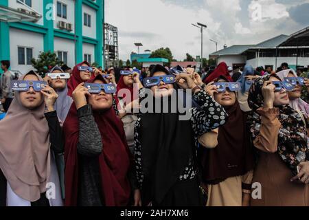 Medan, Nordsumatra, Indonesien. 26 Dez, 2019. Junge muslimische beobachten Sie den Mond bewegen, bevor die Sonne in einem seltenen "feuerring" Sonnenfinsternis in Medan am Dezember 26, 2019, Indonesien. Dieses Phänomen, auch bekannt als die ringförmige Finsternis 'Ring Of Fire' überquert die Kreuzung der sonnenfinsternisse wie in Indien, Malaysia, Singapur, Indonesien und den Philippinen. Tritt auf, wenn der Mond nicht nahe genug an der Erde um die Sonne, obskuren entlang eines 118 Kilometer hohe Straße, die Malaysia, Singapur, Indonesien und den Philippinen aufgenommen. Credit: Albert Ivan Damanik/ZUMA Draht/Alamy leben Nachrichten Stockfoto