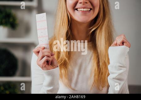 7/8-Ansicht von Frau, Sieger Geste halten Lottery ticket Stockfoto