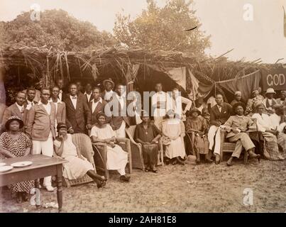 Nigeria, Kennzeichnung auf der Rückseite: "Empire Tag Badagry 1924. Ein Blick auf einige der Besucher. Informelle Gruppe Portrait von Afrikanern und Europäern im Empire Tag feiern im Badragry. Die Gruppe umfasst die europäischen Mitarbeiter von Miller Brüder und die Afrikanische Öl Muttern und ein afrikanischer Priester, 1924. 2000/098/2/30. Stockfoto