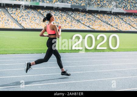 Junge afrikanische amerikanische Sportlerin auf Stadion in der Nähe von 2020 Schriftzug Stockfoto