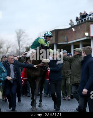 Clan des Obeaux und Jockey Sam Twiston-Davies mit Trainer Paul Nicholls nach dem Gewinn der Ladbrokes King George VI Chase bei Tag eines Der Winter Festival in Kempton Park Racecourse. Stockfoto