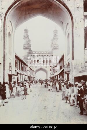 Indien, Fußgänger Linie eine Straße in Richtung der Charminar in Hyderabad, ein Denkmal und die Moschee im Jahre 1591 konstruiert. Beschriftung auf der Rückseite: Char MinaraRs 2/-Manuskripts Bildunterschrift: Char Minar, circa 1905. 2003/071/1/1/3/73. Stockfoto