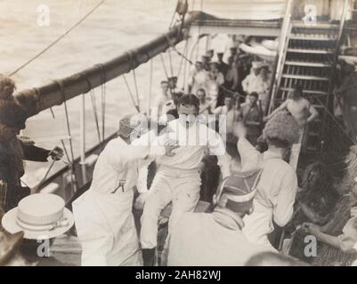 Royal Navy Matrosen an Bord der S.S. Balmoral Castle clown über an Deck tragen Kostüme und Perücken während einer traditionellen "Kreuzung der Linie "naval Initiationsritus. Wahrscheinlich Atlantischer Ozean, im Oktober 1910, 1910. 1995/076/1/4/1/8. Stockfoto