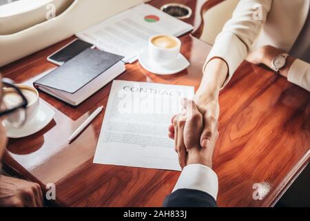 Der Geschäftsmann und Geschäftsfrau Hände schütteln im privaten Flugzeug 7/8 Stockfoto