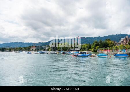 Boote auf dem See von Zürich, mit Hintergrund der schönen Gebäude am Seeufer in Zürich, Schweiz. Stockfoto