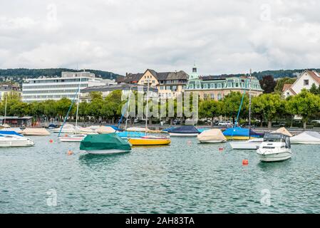 Boote auf dem See von Zürich, mit Hintergrund der schönen Gebäude am Seeufer in Zürich, Schweiz. Stockfoto