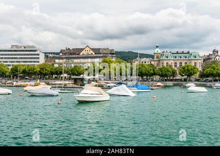 Boote auf dem See von Zürich, mit Hintergrund der schönen Gebäude am Seeufer in Zürich, Schweiz. Stockfoto