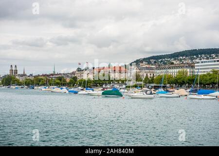 Boote auf dem See von Zürich, mit Hintergrund der schönen Gebäude am Seeufer in Zürich, Schweiz. Stockfoto