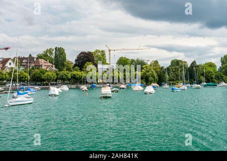 Boote auf dem See von Zürich, mit Hintergrund der schönen Gebäude am Seeufer in Zürich, Schweiz. Stockfoto