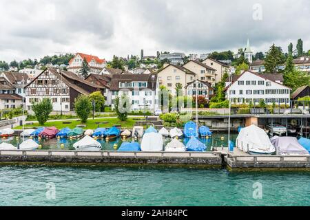 Boote auf dem See von Zürich, mit Hintergrund der schönen Gebäude am Seeufer in Zürich, Schweiz. Stockfoto