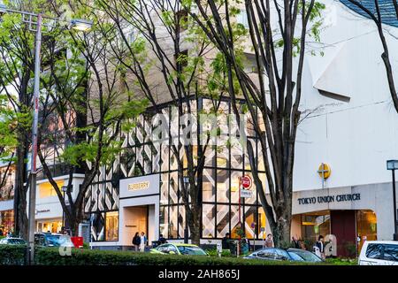 Über street view der Britischen modische Burberry Store unter der Omotesando Avenue. Blaue Stunde, Gebäude beleuchtet. Tokyo Union Kirche daneben. Stockfoto