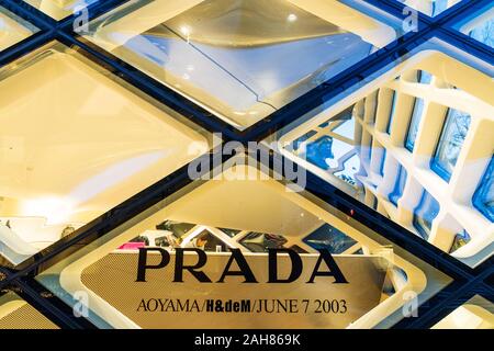 Prada Aoyama store, Tokio. Ein Glas Kristall Gebäude aus Rautenförmigen-Scheiben, beleuchtet, Nacht. Nahaufnahme von Glasscheiben mit Prada-Logo. Stockfoto