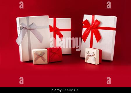 Sortiert weiße Geschenkboxen auf rotem Hintergrund. Stockfoto