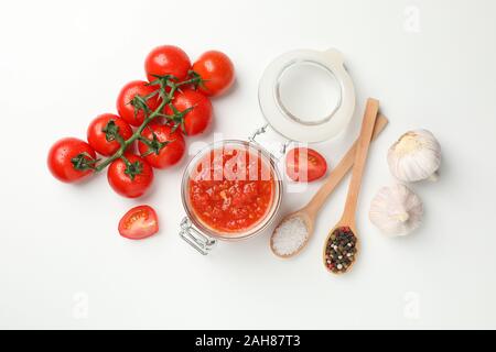 Chili Sauce im Glas und Zutaten auf weißem Hintergrund, Platz für Text. Ansicht von oben Stockfoto