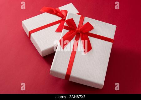 Sortiert weiße Geschenkboxen auf rotem Hintergrund. Stockfoto
