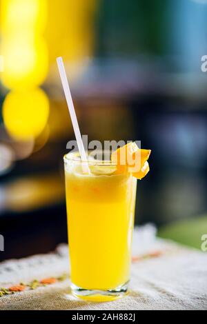 Frische tropische mango Saft in ein Glas mit Stroh mit einem karambolen Slice eingerichtet. Stockfoto