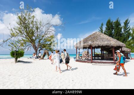 Gruppe von Touristen gehen an den schillernden Strand zum Sonnenbaden, schwimmen und entspannen, Kuba Stockfoto