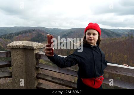 Mädchen stehen auf einem Hügel in der Nähe von einem See in den Bergen, self portrait Stockfoto