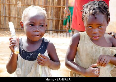 Zwei afrikanische Kinder essen mandioca mit ihren eigenen Händen. Stockfoto