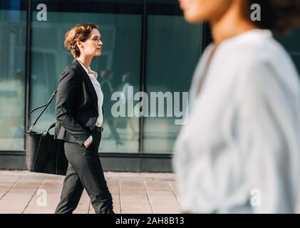 Geschäftsfrau pendeln ins Büro tragen ihre Tasche. Frau in formale Walking im Freien. Stockfoto