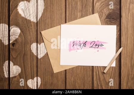 Mockup Brief und Umschlag auf Holz mit mit Liebe Text. Mock up für elegantes Design. Flach tag Vintage Retro Hintergrund Konzept der Ansicht von oben Valentine. Stockfoto