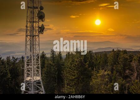 Fernmeldeturm, Antenne und Satellitenschüssel über Sumava Wald. Stockfoto