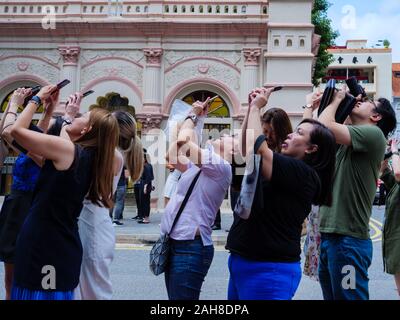 Singapur - 26 Dez 2019 - Masse der Schaulustigen im Central Business District (CBD) Schauen Sie sich das "Ring of Fire", Sonnenfinsternis, Fotos zu machen und die gemeinsame Nutzung von o Stockfoto