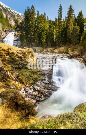 Weitwinkelansicht eines Doppelwasserfalls, der zwischen Bäumen und Felsen in einem österreichischen Nationalpark fließt Stockfoto