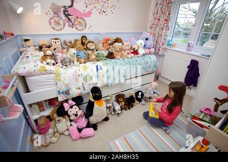 Junge Mädchen lesen auf Spielzeug in Ihrem Schlafzimmer Stockfoto