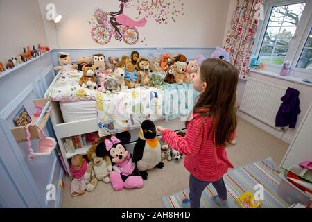 Junges Mädchen mit Spielzeug spielen im Schlafzimmer Stockfoto