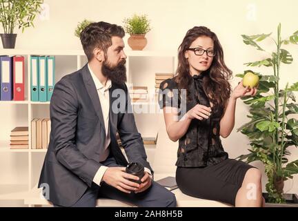 Büro Mittagessen. Mann und Frau Gespräch während der Mittagszeit. Büro Gerüchte. Paar Kollegen Mittagspause entspannen. Anteil Mittagessen mit Kollegen. Flirten Kollegen. Mann und attraktive Frau mit Bart. Stockfoto