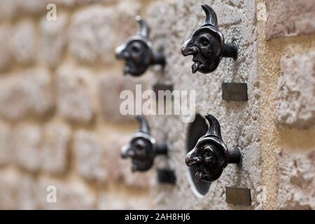 Nahaufnahme von seltsamen türklingeln aus venetianischen Messing an einer adobe-wand Stockfoto