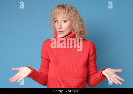 Frau wirft Hände zuckte mit den Schultern, unsicher In einige Zweifel Stockfoto