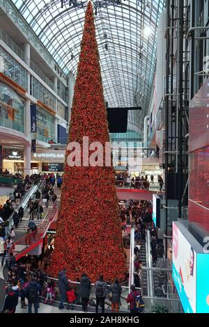 TORONTO - Dezember 2019: die Eaton Center Shopping Mall ist hell für Weihnachten dekoriert als besetzt Käufer auf verschiedenen Ebenen gehen. Stockfoto