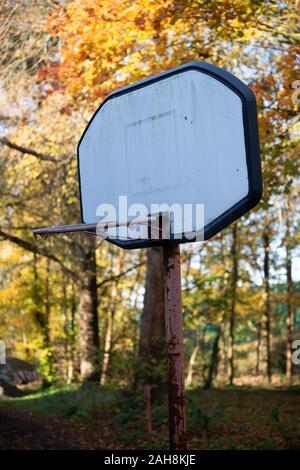 Abgenutzt, Basketballkorb in die Wälder gegen treibt und blauer Himmel Stockfoto