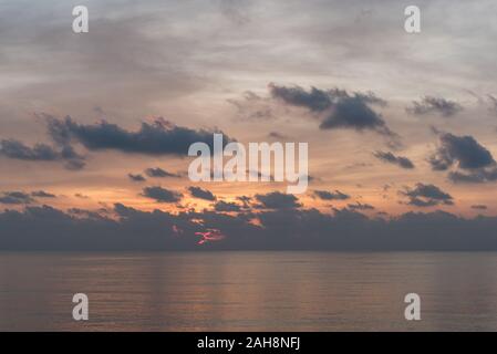 Sonnenaufgang auf dem Meer Horizont mit noch Seawaters, dunkle Wolken und orange Spiel in den Himmel. Am frühen Morgen am Golf von Thailand in Prachuap Khiri Khan Stockfoto