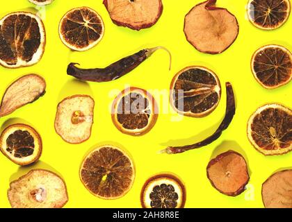 Scheiben getrocknete Orangen auf gelben Hintergrund. Neues Jahr oder Weihnachtskarte. Stockfoto