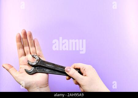 Zwei Johannisbrot Schraubenschlüssel in der Hand komprimiert und liegen auf dem Palm von der anderen. Stockfoto