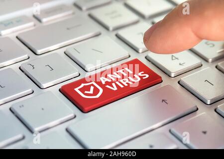 Computer Taste der Internetkriminalität. Die Inschrift auf der Tastatur, Antivirus, Finger drückt eine Taste auf dem Laptop. das Konzept der Erfolg online. Stockfoto