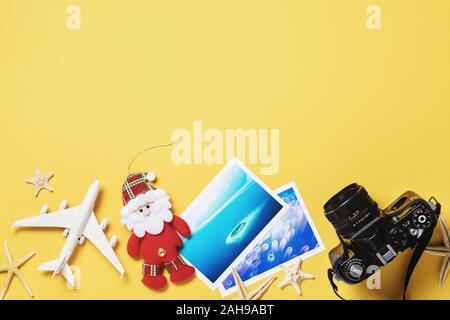 Spielzeug Flugzeug, Fotos und Kamera auf einem gelben Hintergrund mit kopieren. Weihnachten reisen Planung Konzept Stockfoto