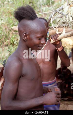 Hamer Stamm junge Mensch wird bei Bull springen Zeremonie, Omo Valley, Äthiopien Stockfoto