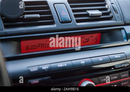 Anzeige der Multimedia System des Autos ist leuchtend rot in der Nacht über das Radio, Klimaanlage Temperatur und andere Tools zu m Stockfoto