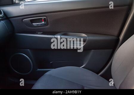 Das Innere des Wagens mit Blick auf die Fahrgäste Tür mit Knöpfen, Armlehne und schwarz Polsterung nach Details und chemische Reinigung. Auto Service i Stockfoto