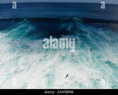 Luftaufnahme der Surfer auf der Leiterplatte verfängt, die Wellen, grosse Wellen tropischen blauen Ozean, Bali, Indonesien Stockfoto