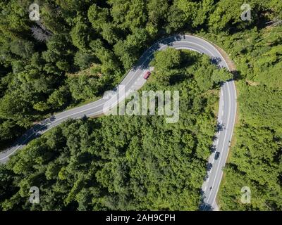 Serpentine, Biegen eines Landes Straße durch Nadelwald in den Bergen von oben, Luftaufnahme, Kochel, Oberbayern, Bayern, Deutschland Stockfoto