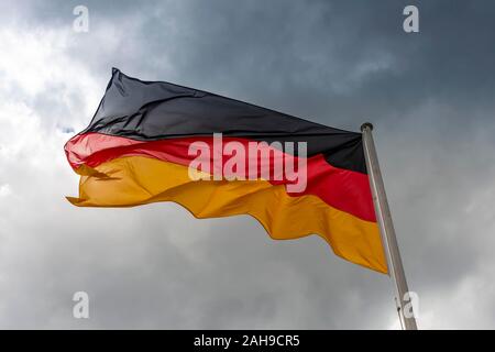 Deutschland Fahne im Wind vor dunklen Wolken, schwarz-rot-gold, Berlin, Deutschland Stockfoto