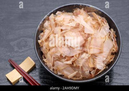 Japanisches Essen, Katuobushi auf gekochten Reis auf schwarzem Hintergrund Stockfoto