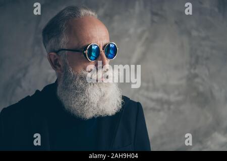 Close up phoro konzentrierter rauen männlichen alte Person in Brillen Brillen suchen tragen Mantel Blazer über grauer Hintergrund Stockfoto