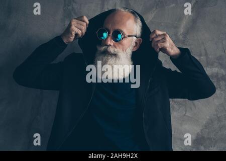 Nahaufnahme Foto von herrlich rauen männlichen Mann mit Kapuze auf grauen Hintergrund träumen Stockfoto